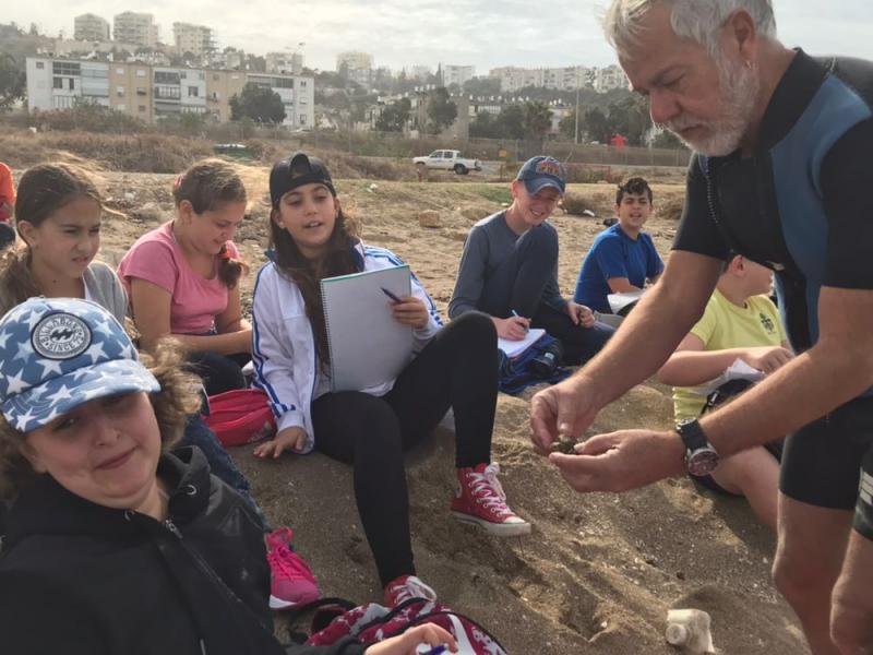 חוקרים בעלי חיים בחוף הים יחד עם החוקר הימי